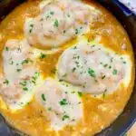 French onion chicken in a cast iron skillet garnished with parsley