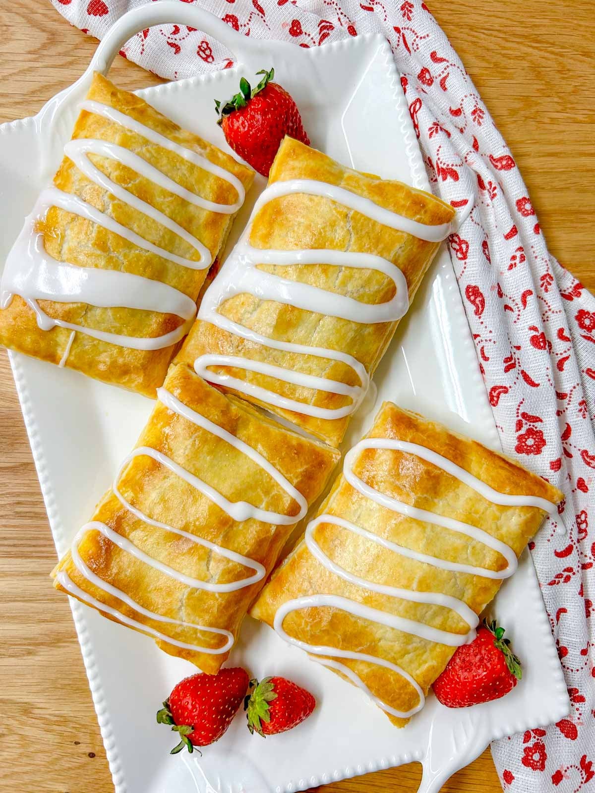 a white platter with 4 strawberry homemade toaster strudel