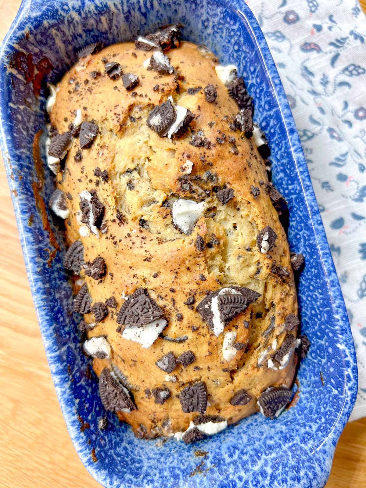 a loaf of Oreo banana bread is in a blue and white loaf pan.