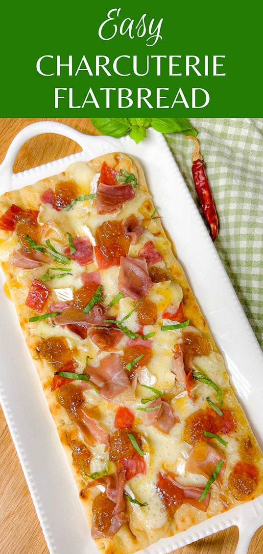 a white platter has a charcuterie flatbread on top that is garnished with thinly sliced basil. text overlay reads easy charcuterie flatbread.