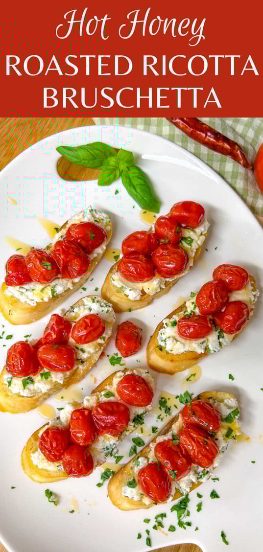 a white serving platter has pieces of hot honey roasted bruschetta on top and is garnished with hot honey, basil, and parsley. text overlay shows the name of the recipe.