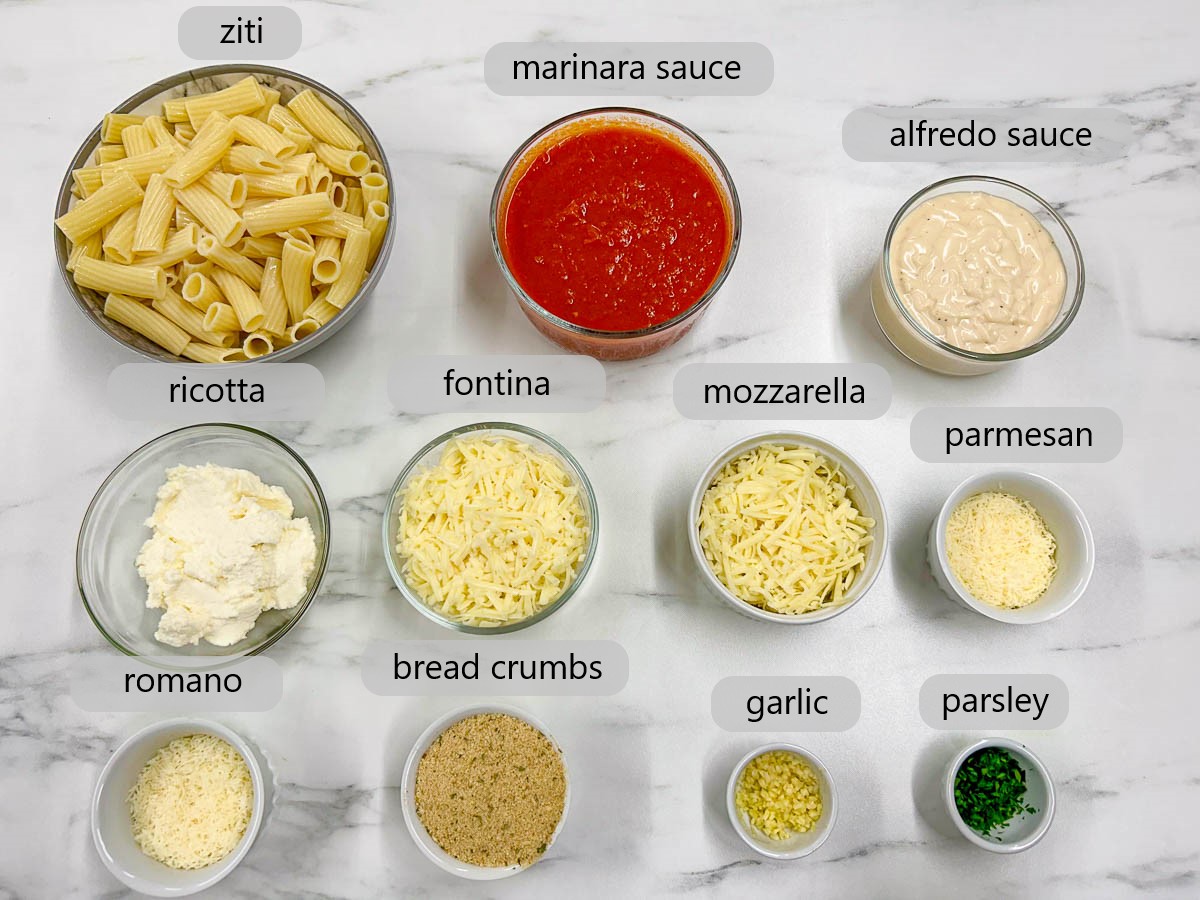 a white marble countertop has bowls with ingredients and text overlay reading ziti, marinara sauce, alfredo sauce, ricotta, fontina, mozzarella, parmesan, romano, breadcrumbs, garlic, and parsley.