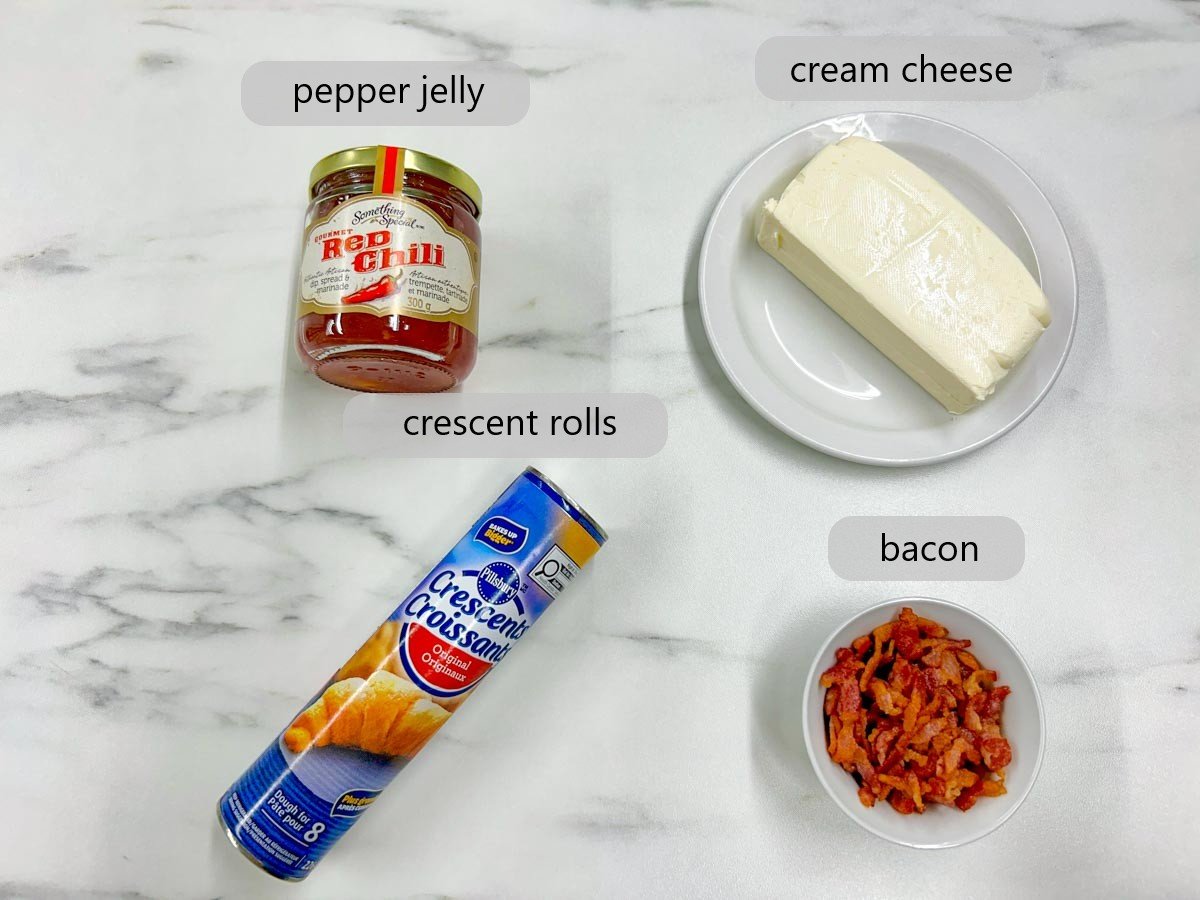 a countertop with the ingredients to make bacon pepper jelly cheese cups with text overlays reading pepper jelly, cream cheese, crescent rolls, and bacon.
