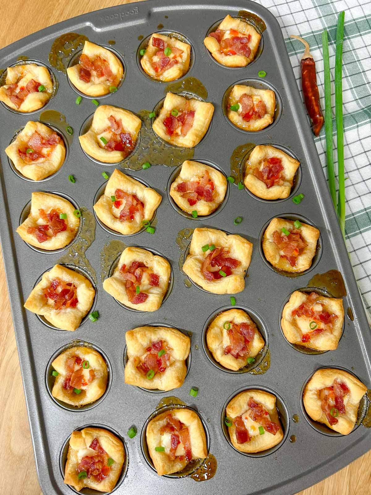a mini muffin tin is filled with bacon pepper jelly cheese cups