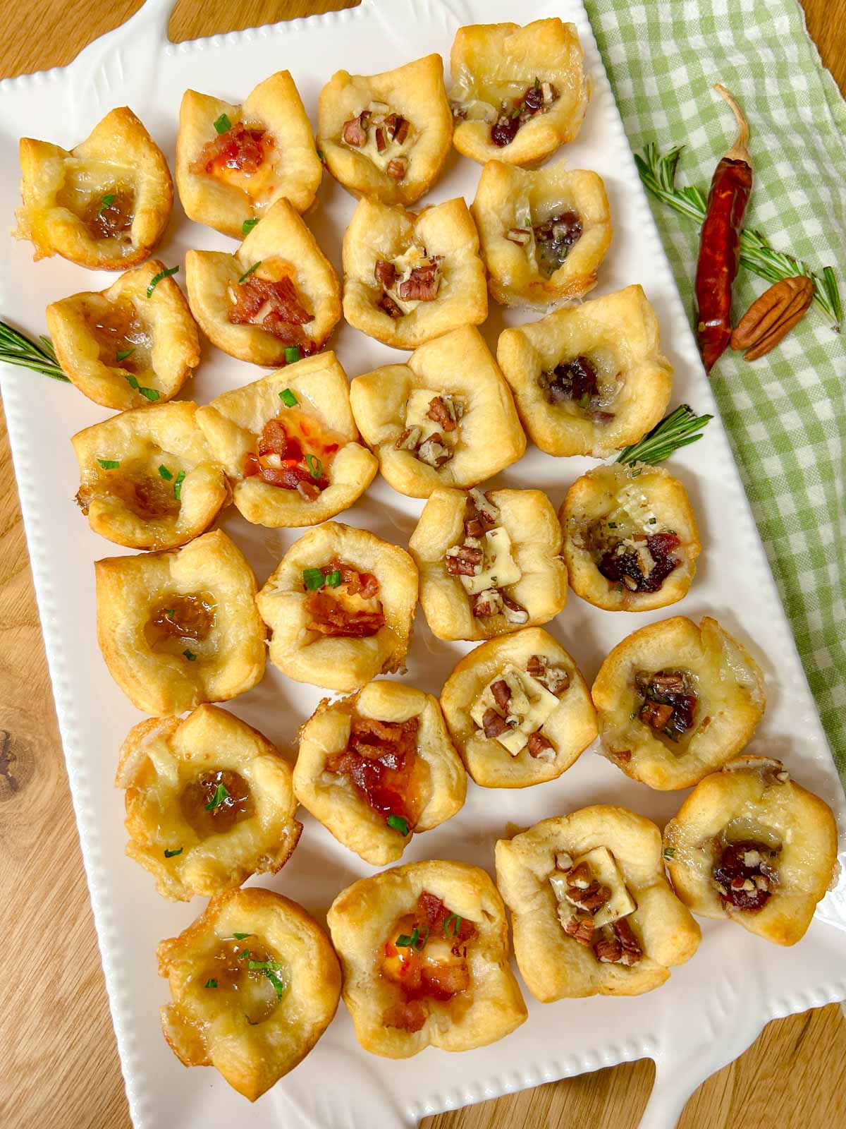 a white platter with 4 different flavors of baked cheese cups.