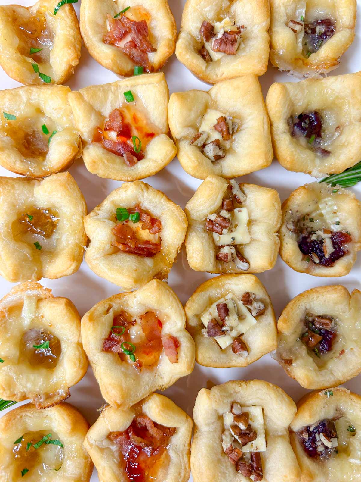 a white platter with 4 different flavors of baked cheese cups.