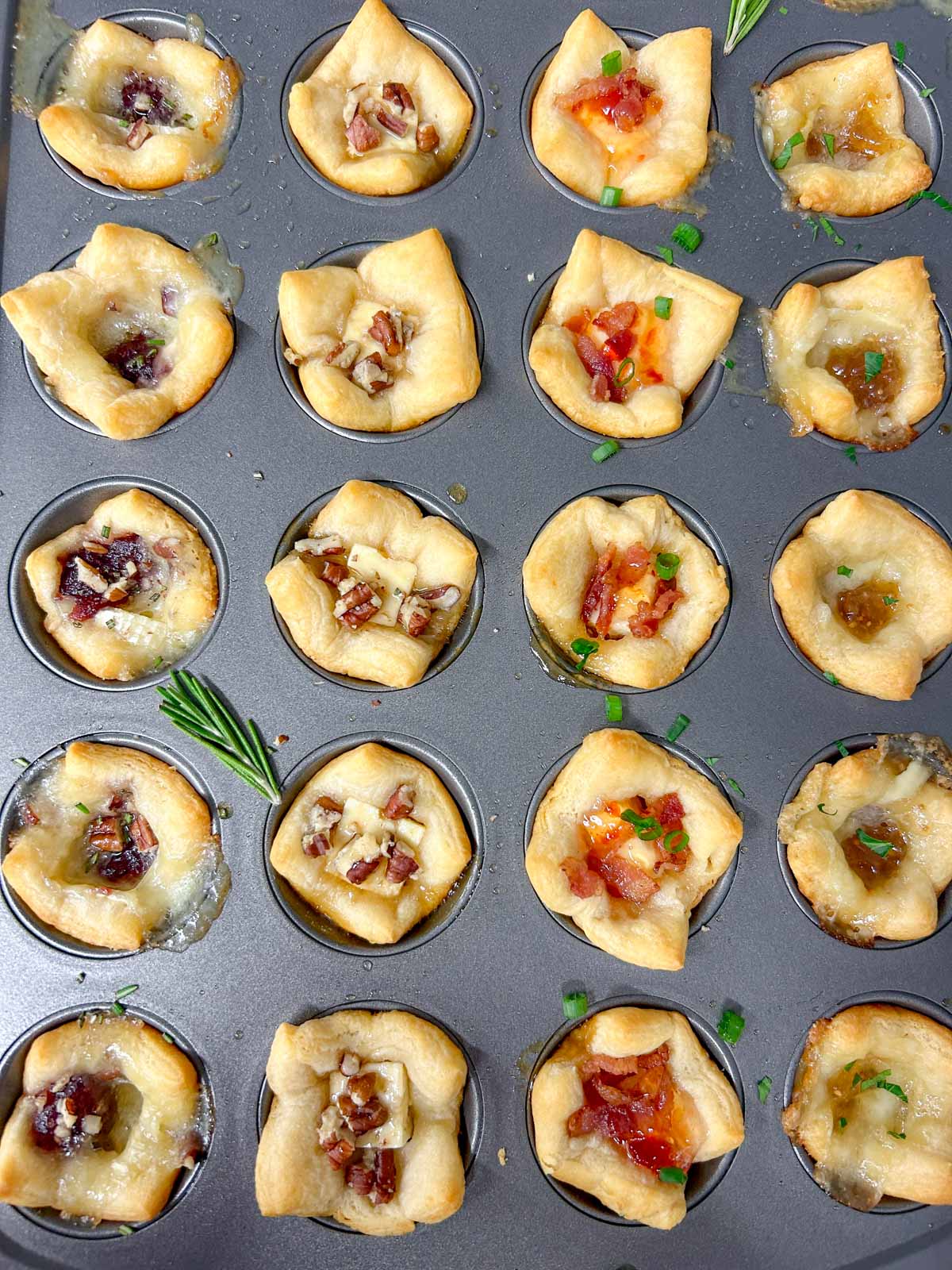 a muffin tin with 4 different flavors of baked cheese cups.