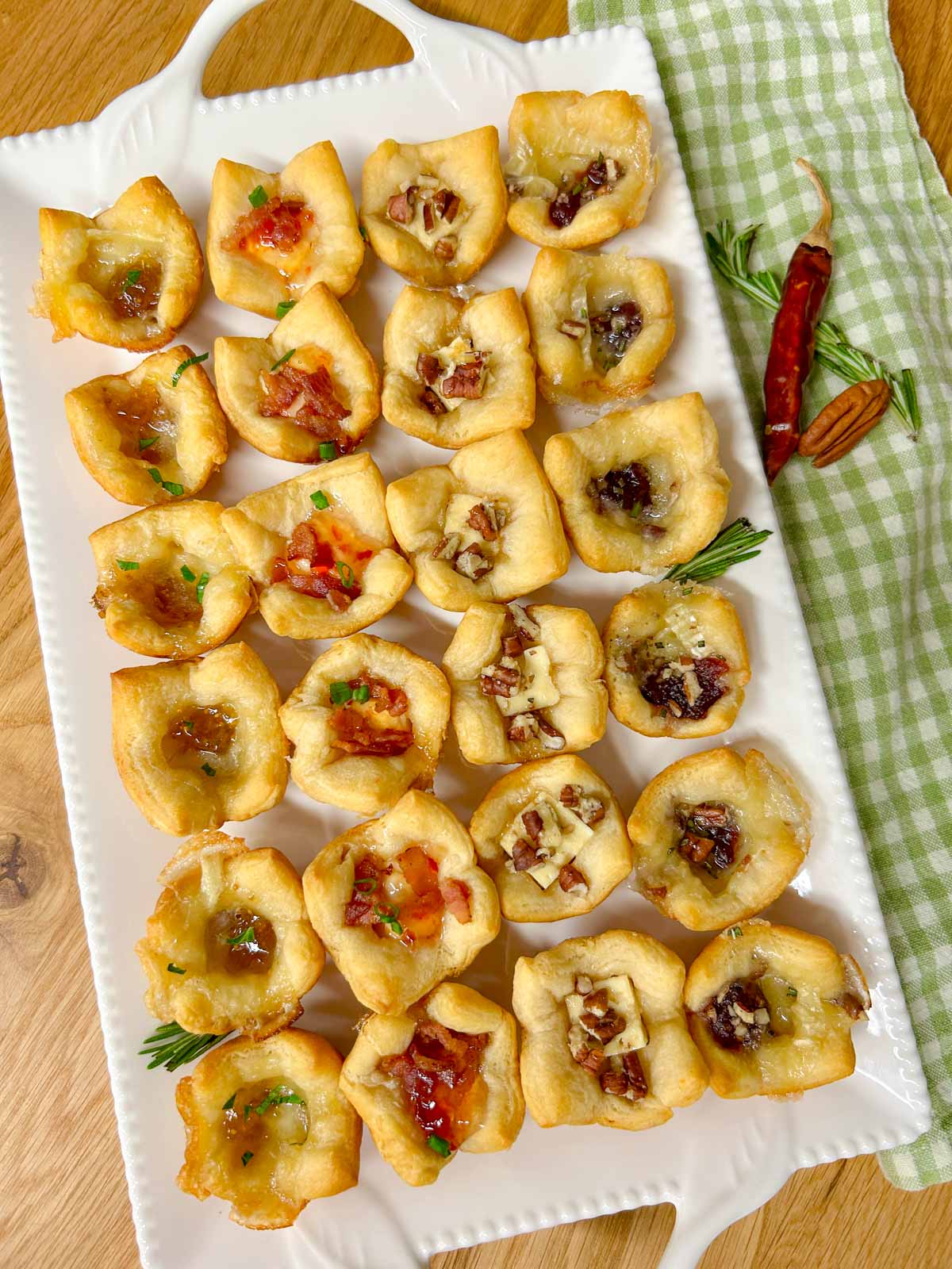 a white platter with 4 different flavors of baked cheese cups.