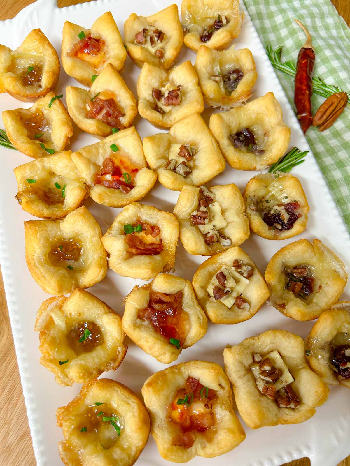 a white platter with 4 different flavors of baked cheese cups.