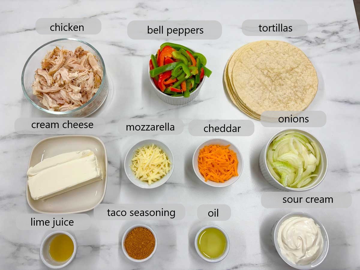 kitchen counter with bowls of ingredients and text overlays reading chicken, bell peppers, tortillas, cream cheese, mozzarella, cheddar, onions, lime juice, taco seasoning, oil and sour cream