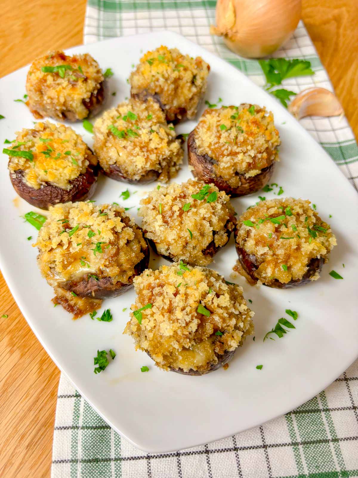 a white plate is filled with French onion stuffed mushrooms and garnished with parsley. 