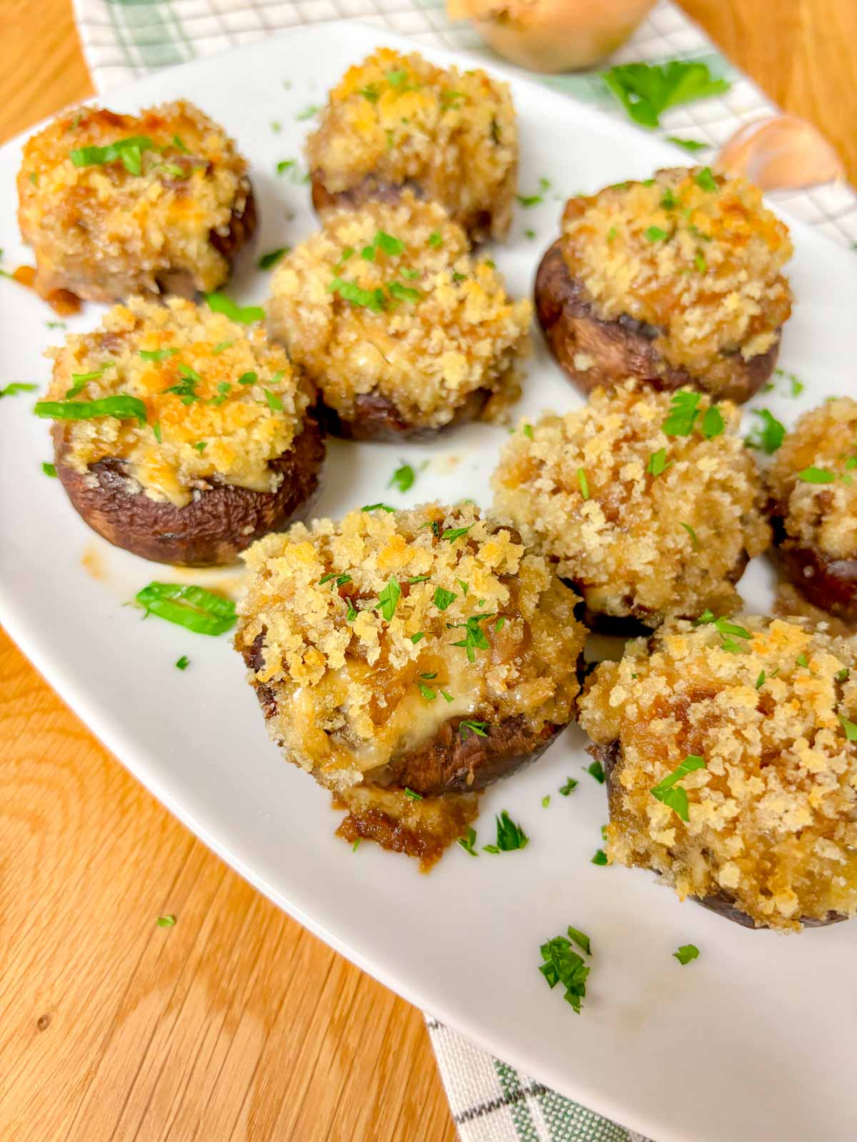 a white plate is filled with French onion stuffed mushrooms and garnished with parsley. 