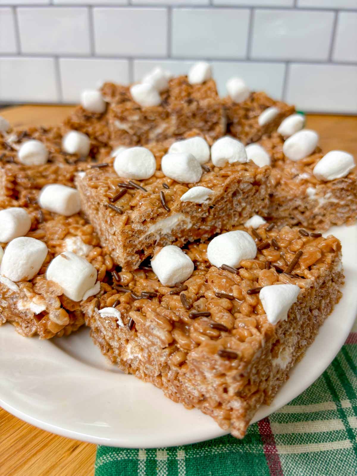 a white platter is filled with hot chocolate rice krispie treats.