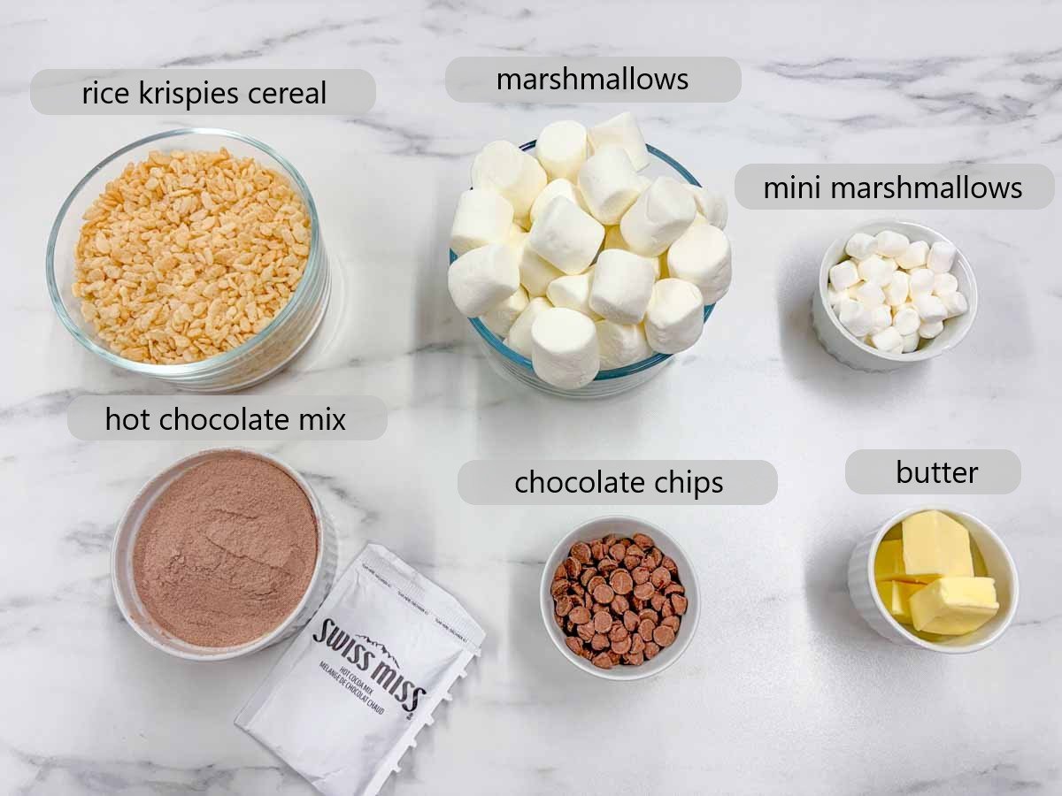 kitchen counter with ingredients and text overlays reading rice krispies cereal, marshmallows, mini marshmallows, hot chocolate mix, chocolate chips and butter