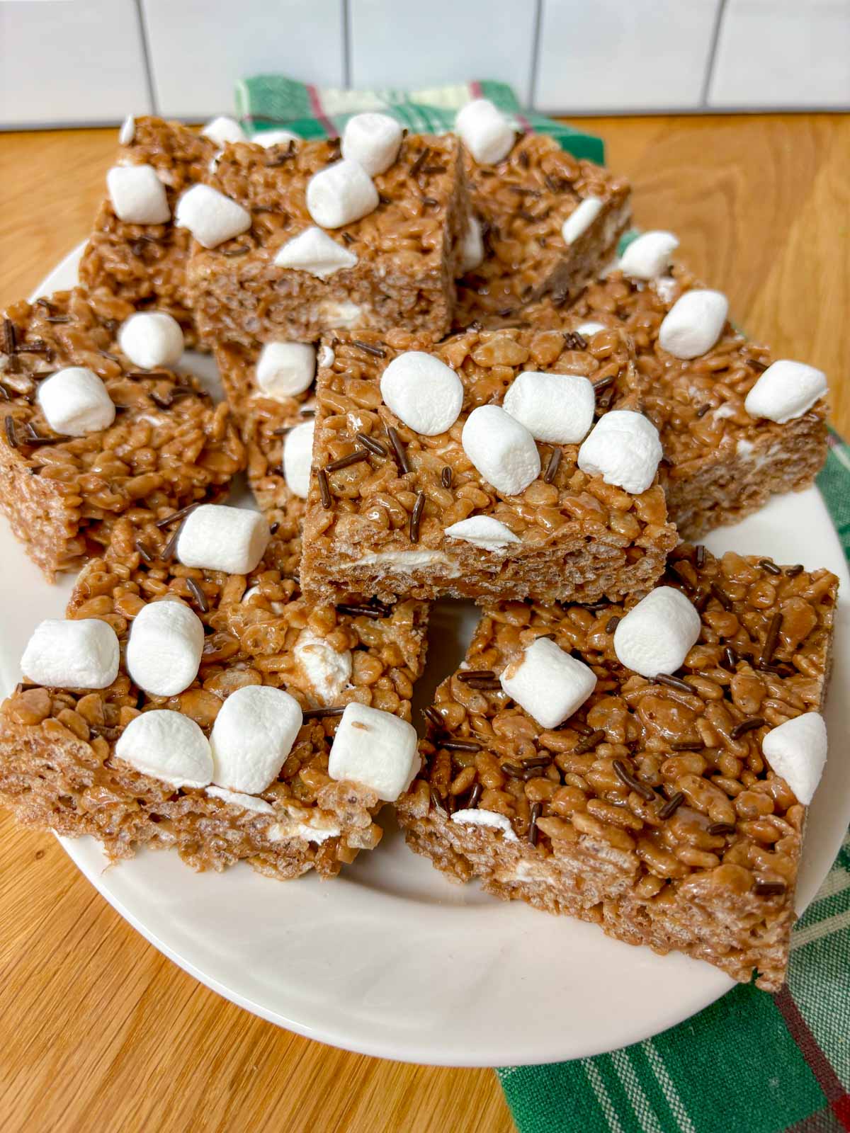 a white platter is filled with hot chocolate rice krispie treats.