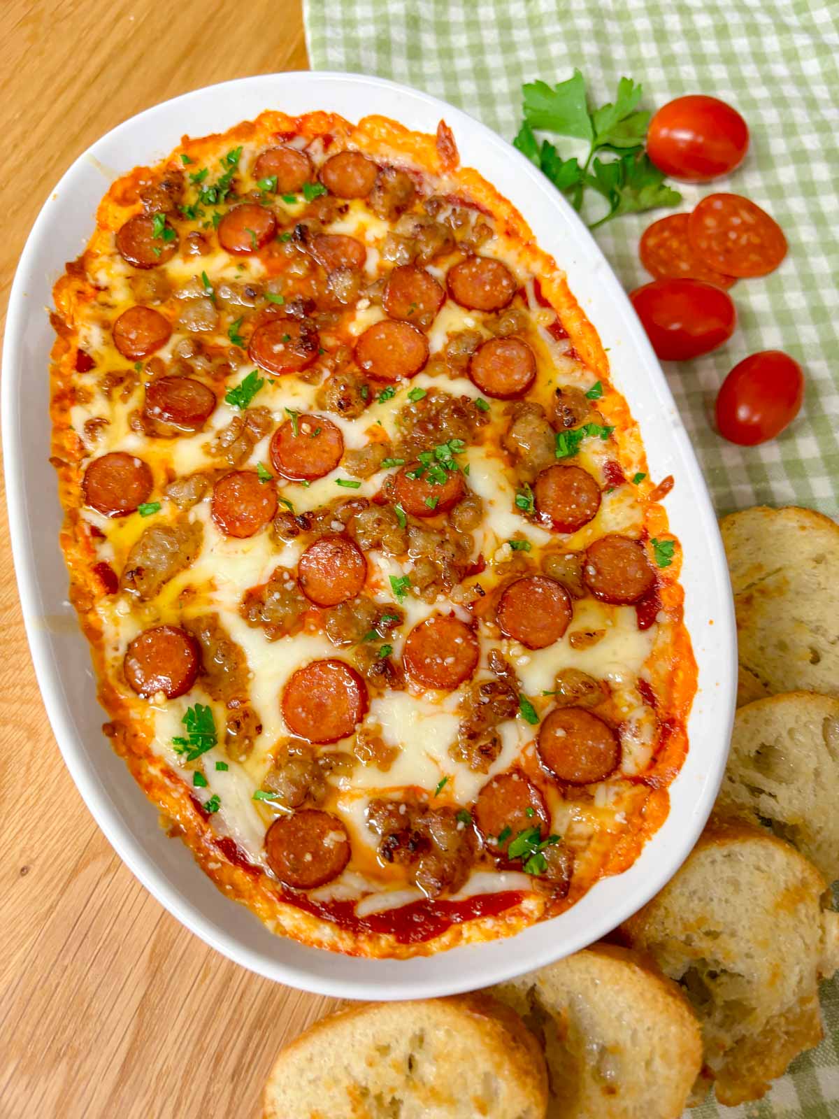 a white baking tray is filled with hot honey pepperoni sausage pizza dip