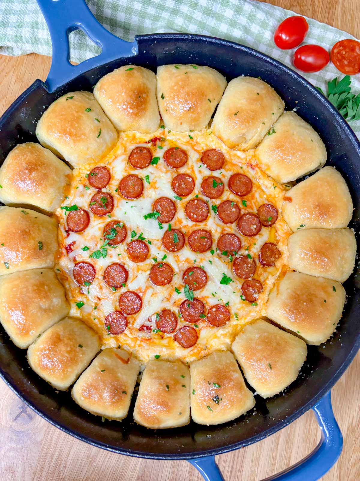 a pizza dip ring with pizza dough balls and a pizza dip in the middle is in a cast iron skillet.