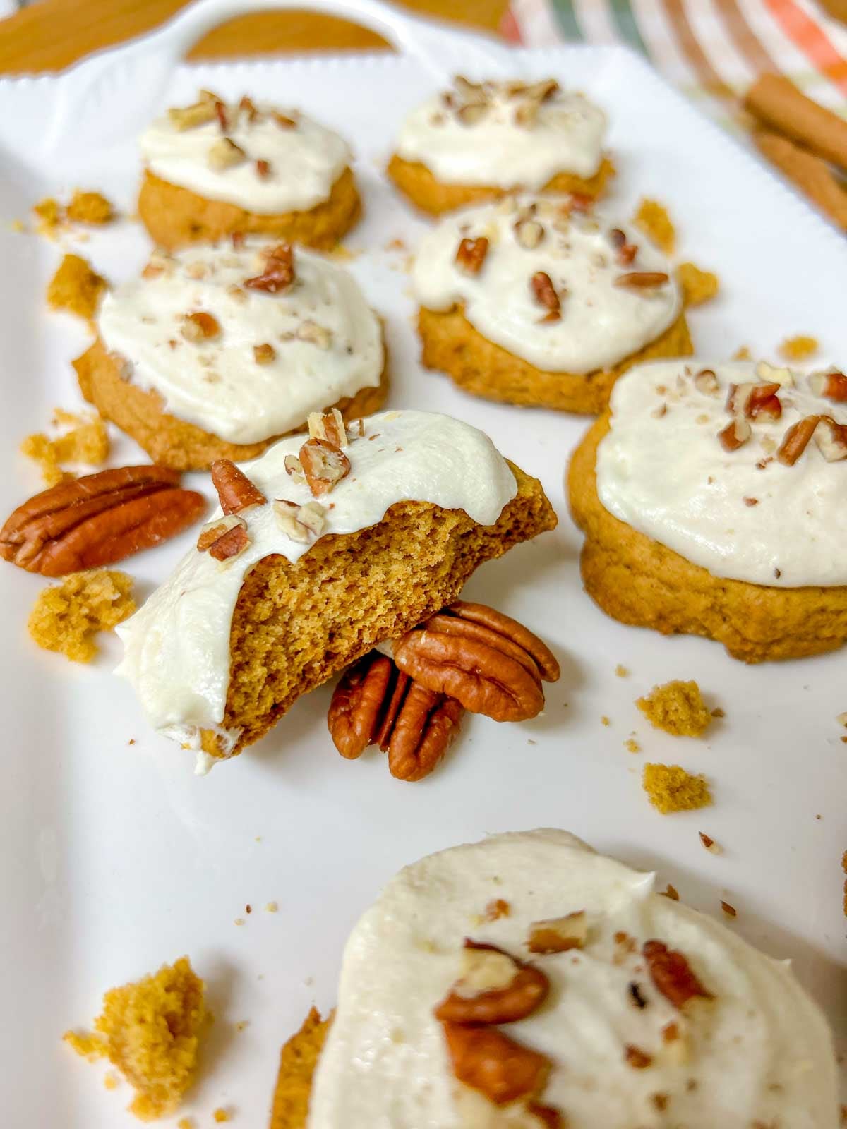close up shot of a cut in half pumpkin spice cookie with cream cheese frosting