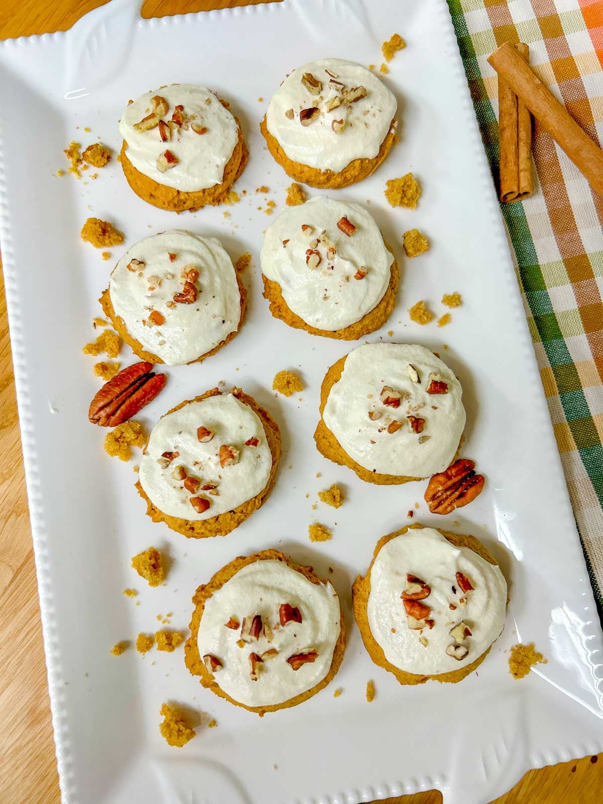 a white plate is filled with cream cheese frosting pumpkin spice cookies