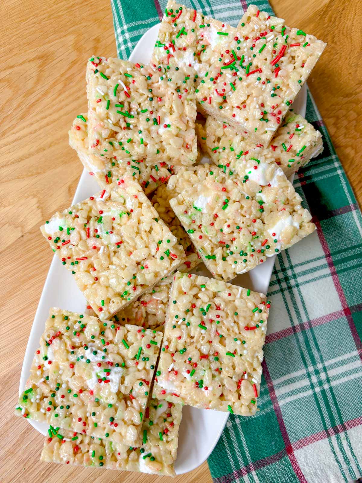 a white platter of sugar cookie rice krispie treats. one is held close to camera