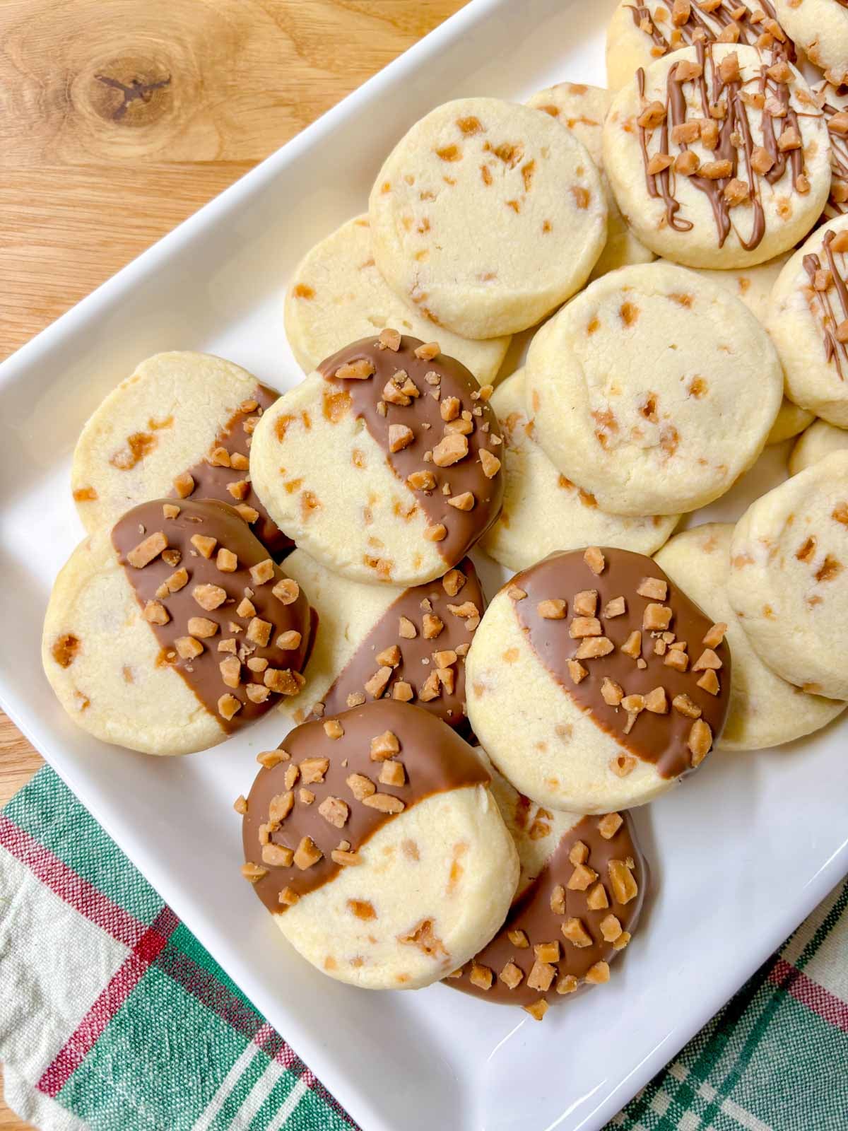 close up shot of a tray of chocolate dipped toffee shortbread cookies