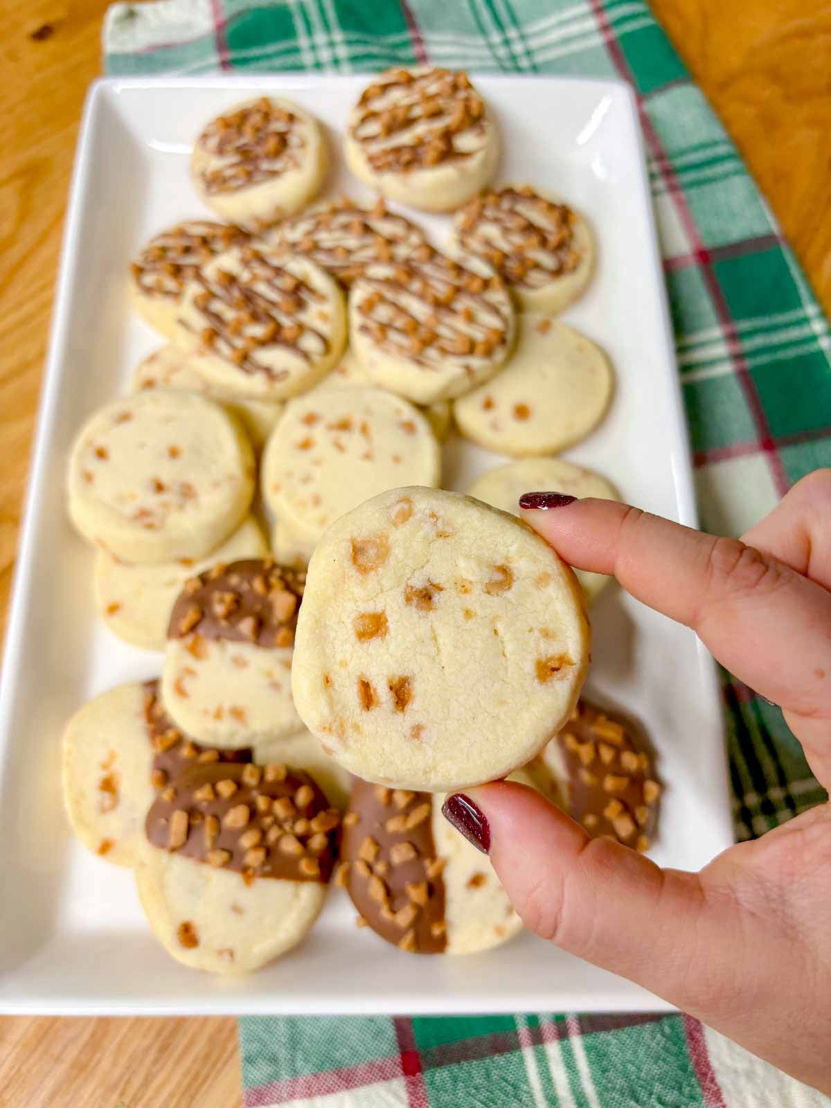 a plain toffee shortbread cookie is held close to camera