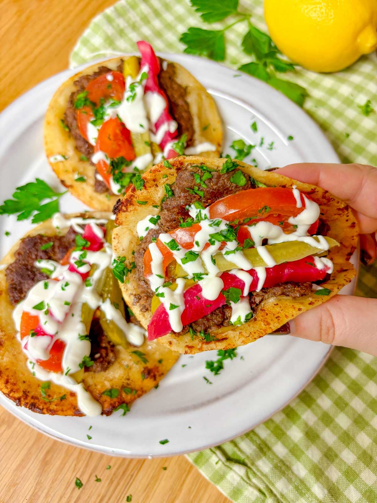 one beef kebab taco is squished closed and held close to camera
