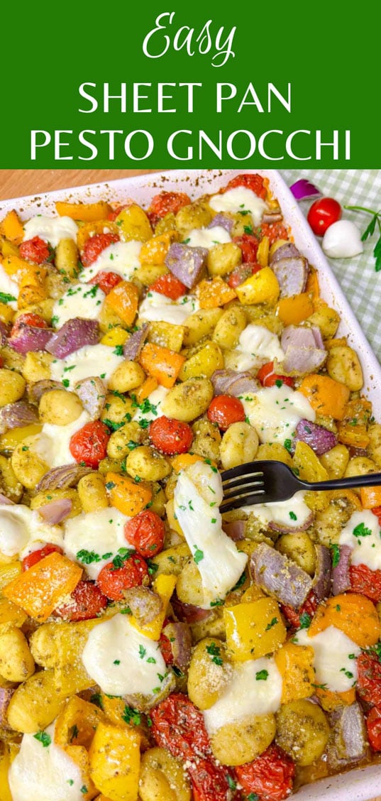 a sheet pan is filled with cheesy pesto gnocchi and garnished with parmesan, basil and parsley. 