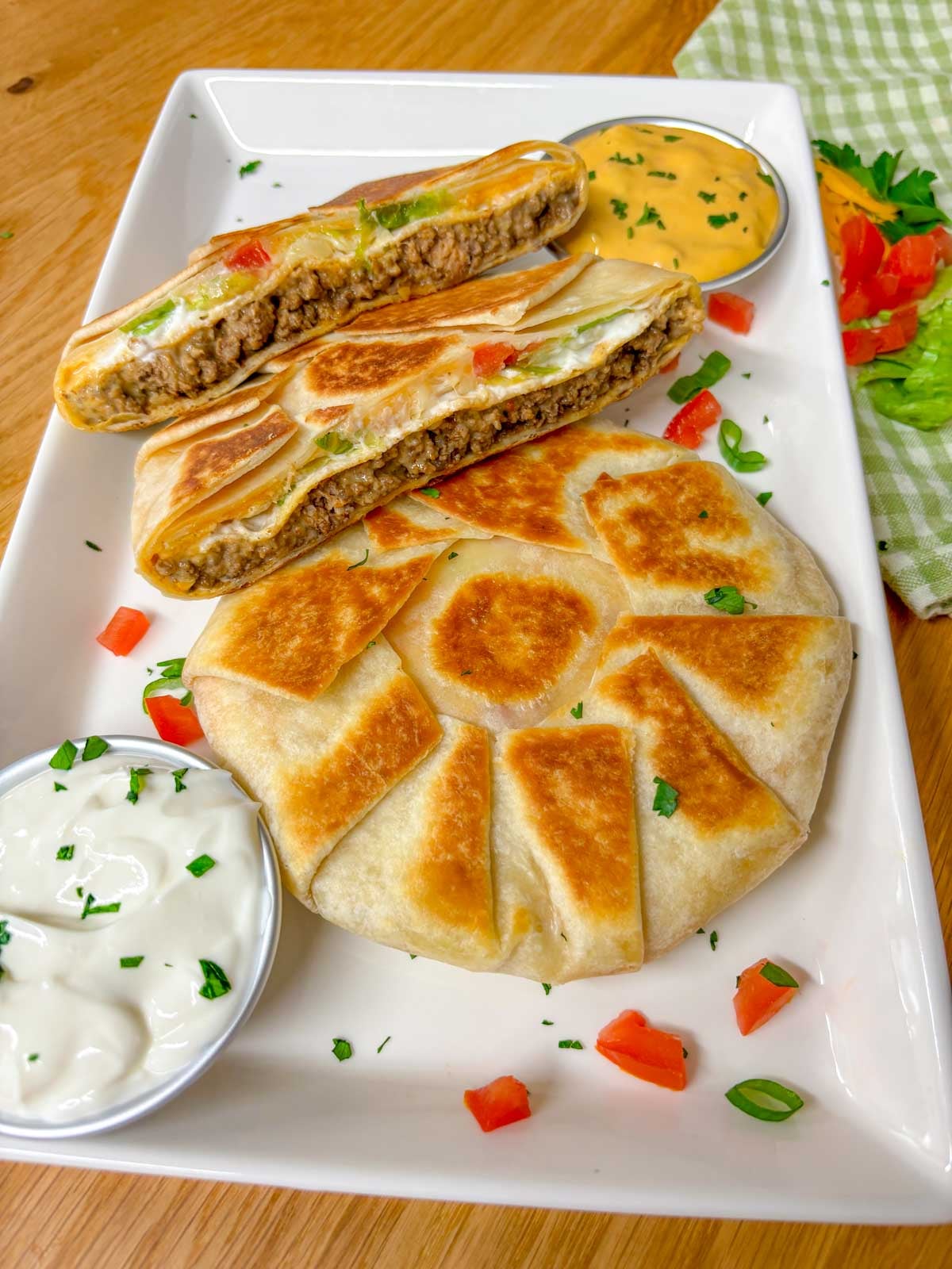 a white plate as two crunchwrap supremes on it. one is cut in half and stacked