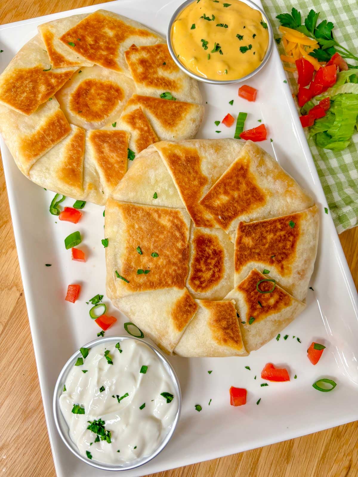 a white plate has two crunchwrap supremes on it. 