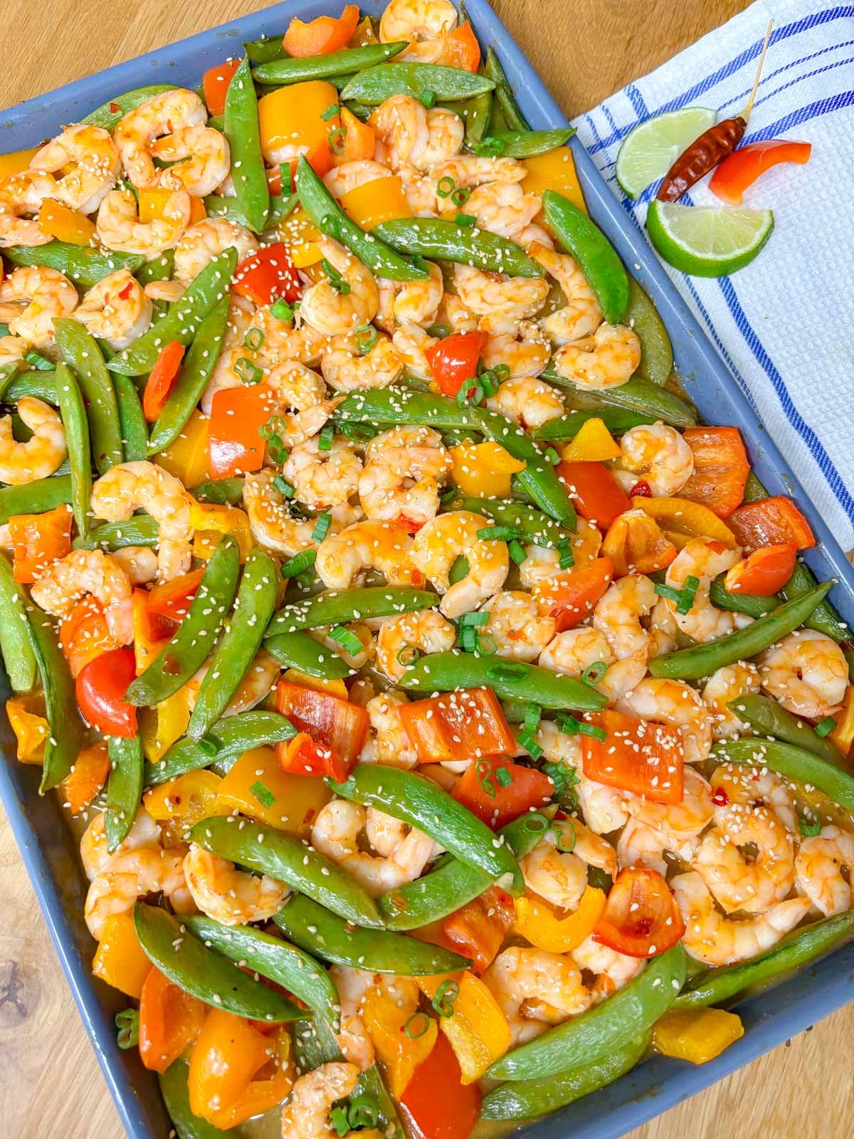 sheet pan filled with roasted veggies and shrimp in a lime sweet chili sauce