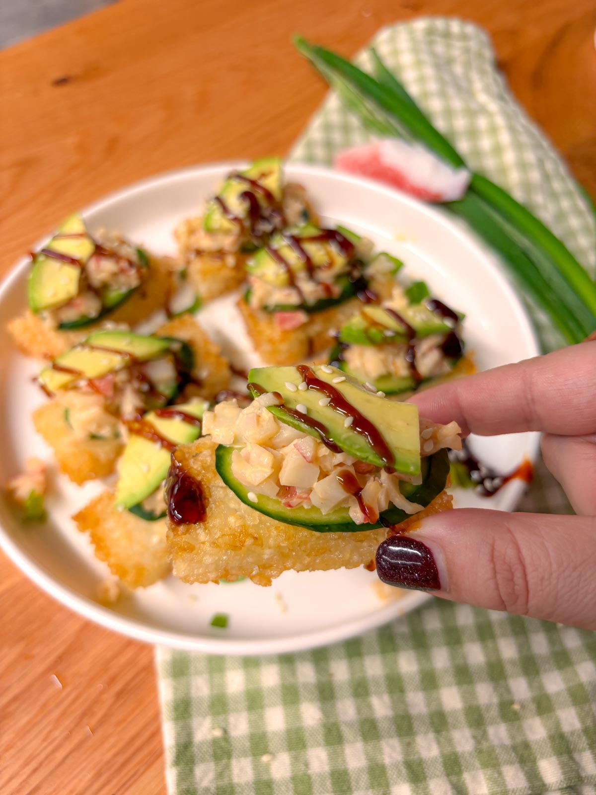a piece of California roll crispy sushi rice is held close to camera