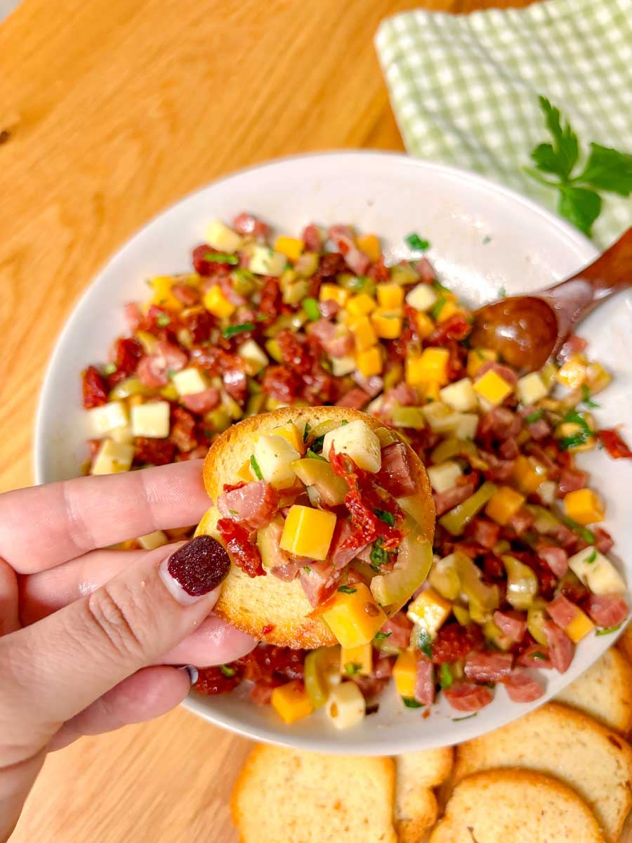 a piece of crostini is topped with charcuterie dip