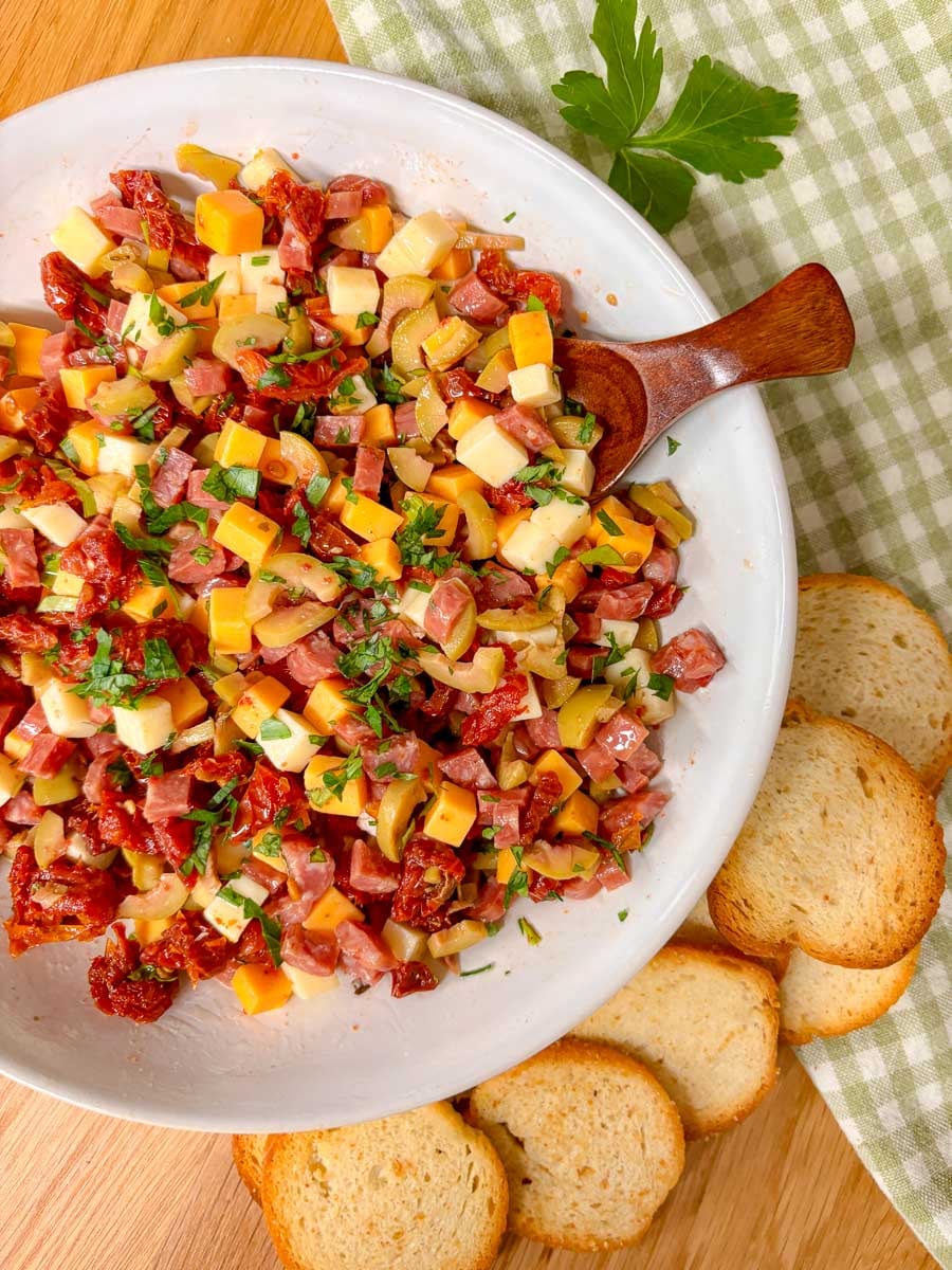 a small spoon is scooping some of the charcuterie dip