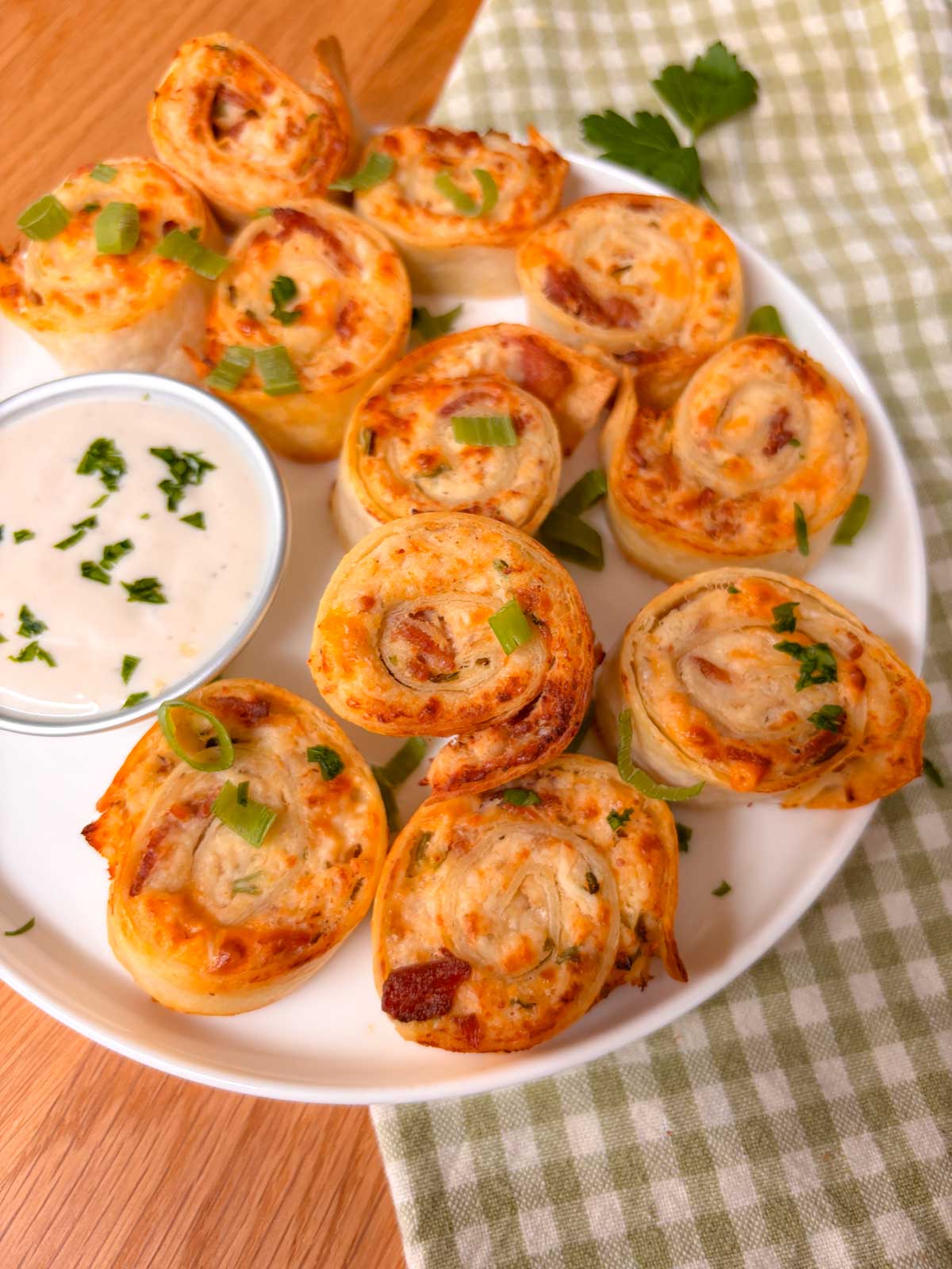 close up of a plate of pinwheels garnished with green onions