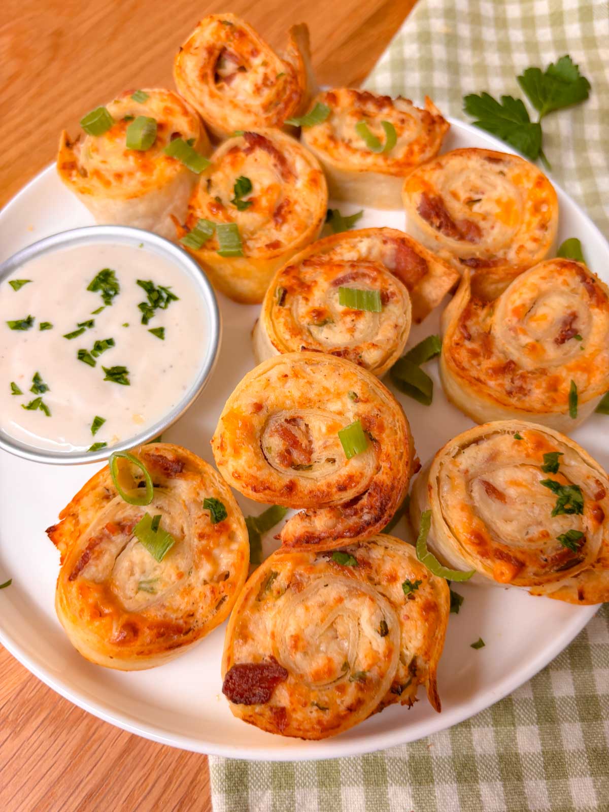 a platter of crispy chicken bacon ranch pinwheels with a side of ranch to dip