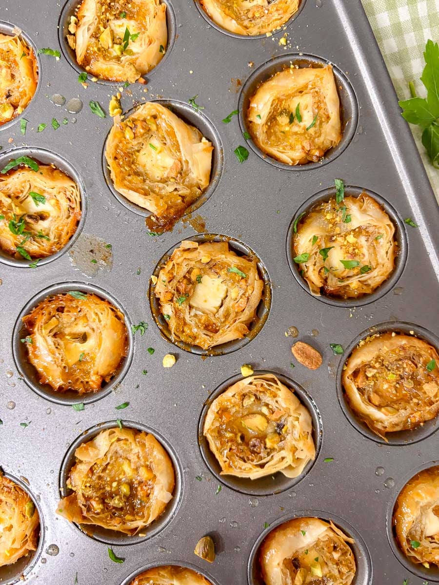 close up shot of a mini muffin tin filled with feta pistachio bites