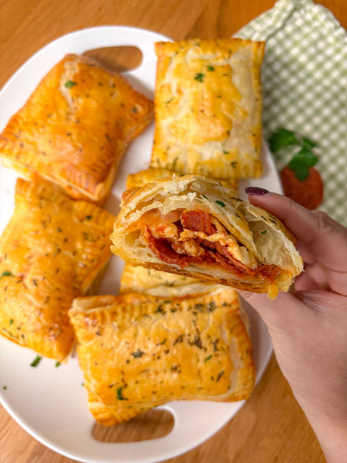 half a hot honey pizza pocket is held close to camera to show the pepperoni, cheese, and sauce filling