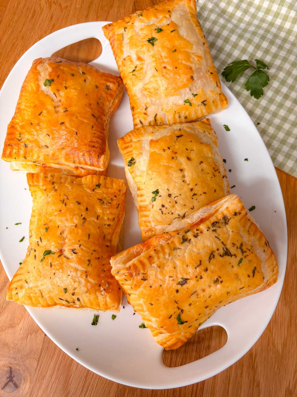a platter with 5 hot honey pizza pockets garnished with parsley